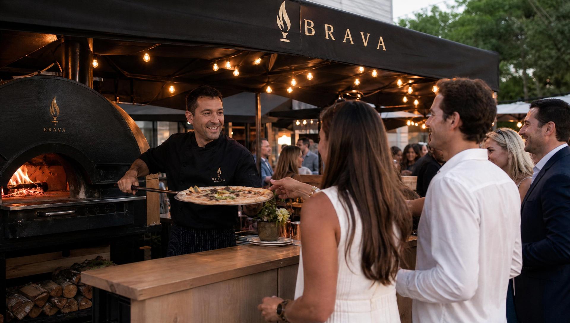 Chef removing a pizza from the wood-fired oven as guests watch and receive it